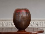 a brown vase sitting on top of a wooden table