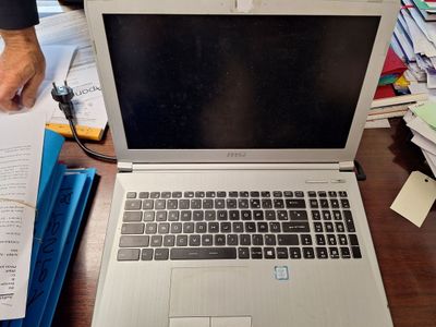 a laptop computer sitting on top of a wooden desk