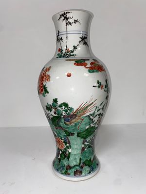 un vase blanc avec un tableau posé sur une table