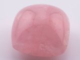 un gros plan d'un caillou rose sur une surface blanche