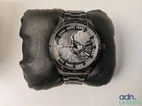 a wrist watch with a skull on it sitting on a glove