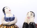 two salt and pepper shakers sitting next to each other