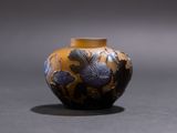 a small vase with a design on it sitting on a table