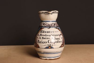 un vase blanc et bleu posé sur une table, sur fond noir