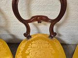 three yellow chairs sitting next to each other on a cement floor
