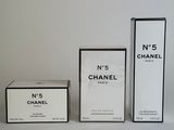 three boxes of perfume sitting next to each other on a white surface