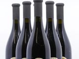 quatre bouteilles de vin sont alignées sur une surface blanche