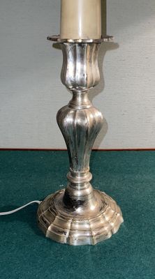 une bougie en argent posée sur une table