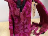 purple purse with a pink purse and a pink purse on a wooden table