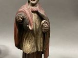 two figurines of a man with a robe and a robe on a wooden base