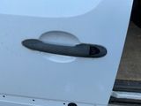une poignée de porte sur une voiture blanche percée d'un trou