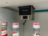 three bottles of soda sitting on a shelf in a refrigerator