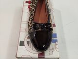 quelqu'un porte une paire de chaussures à imprimé léopard posée sur une boîte