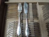 a lot of silver spoons and forks in a box
