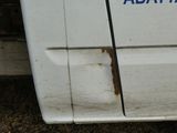 une camionnette blanche avec un autocollant bleu sur le côté