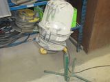 un ventilateur posé sur un trépied dans une pièce