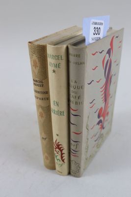 trois livres sont empilés sur une surface blanche