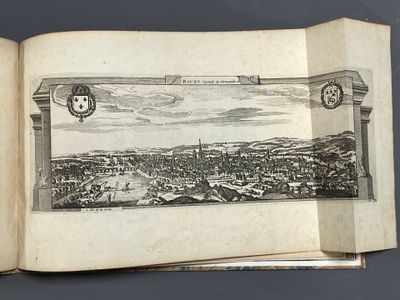 an open book with a drawing of a city on it