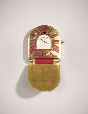 une image représentant une horloge dorée et rouge accrochée à un mur