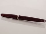a pen sitting on top of a white table next to a glass