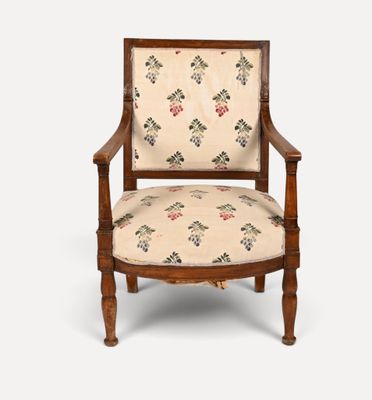 une vieille chaise en bois dont l'assise est recouverte d'un tissu à motifs floraux