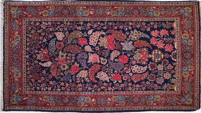 an antique persian rug with floral design on a blue ground