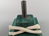 an image of a green book with bones sticking out of it and a stick sticking out of it
