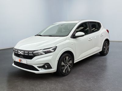 Une voiture blanche est garée dans une pièce au sol noir.