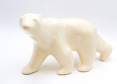 une petite figurine d'ours polaire blanc sur fond blanc