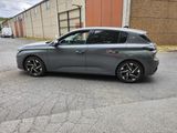 a grey car parked in front of a building on a street