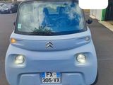 une petite voiture bleue garée sur le bord de la route