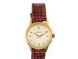 une montre-bracelet plaquée or avec un bracelet en cuir marron