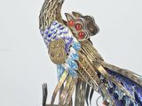 a statue of a bird that is on a wooden stand