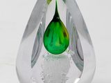 a glass vase with a green flower inside of it