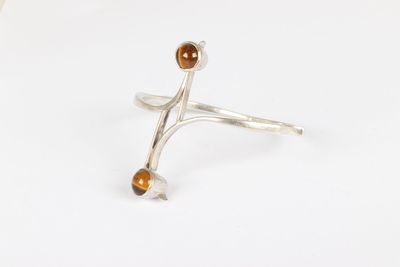 a close up of a silver ring with a brown stone on it
