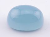 une image représentant une boule de verre bleue posée sur une surface blanche