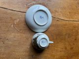 a small cup and saucer sitting on a table