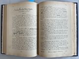 un livre ouvert avec une écriture dessus, posé sur une table