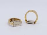 two gold and silver rings on a white surface