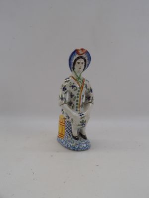 a figurine of a woman sitting on a stool