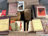 de nombreux livres dans une boîte en carton posée sur une table