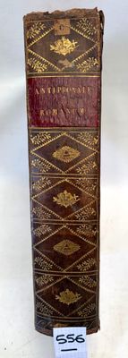 an old book sitting on top of a white table next to a tag