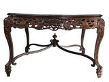 an ornately carved console table with a marble top