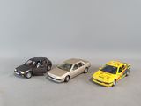 three toy cars are lined up in a row on a white surface