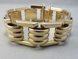 une image d'un bracelet en or sur une surface blanche
