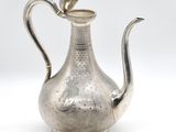 an antique silver tea pot with a bird on top of it