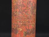 a close up of a red and gold vase on a black background