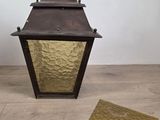 an old fashioned lantern with a small piece of paper next to it