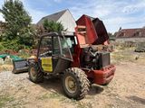 a tractor that is sitting in the dirt near a house