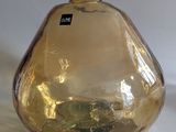 a yellow glass bottle with a black label sitting on a white surface